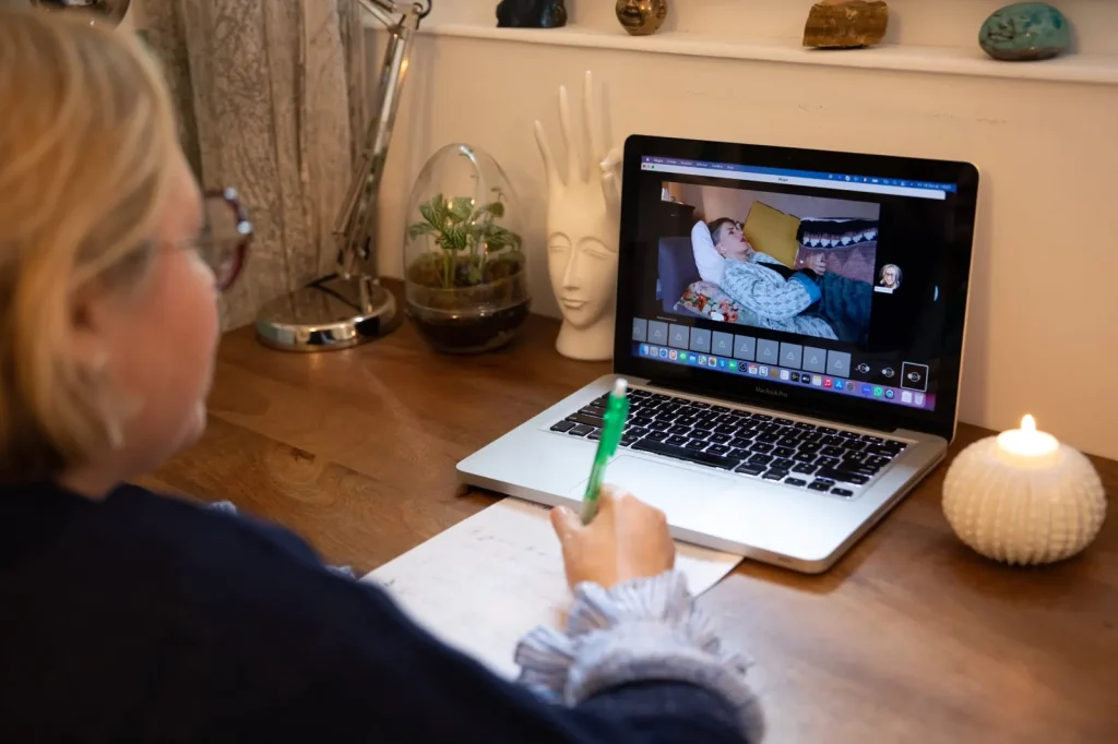 Marie guide une constellation en visio, la personne allongée chez elle apparaît à l'écran